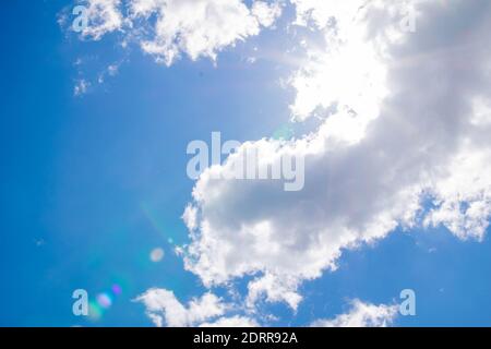 Cumulus Wolken am blauen Himmel und Sonnenstrahlen brechen durch die Wolken. Speicherplatz kopieren Stockfoto