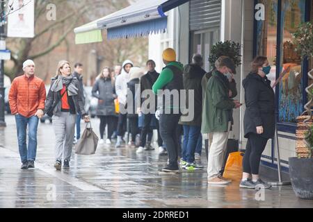 Clapham, London, 21. Dezember 2020: Im Regen stehen die Leute Schlange, um Weihnachtsaufträge von einem lokalen Metzger zu sammeln. Unter Tier 4 Coronavirus Einschränkungen sollten die Menschen zu Hause bleiben, außer für wesentliche Einkäufe und zur Arbeit zu gehen. Cafés und Restaurants sind nur für Essen zum Mitnehmen geöffnet und Deliveroo liefert Lebensmittel sowie warme Mahlzeiten. Anna Watson/Alamy Live News Stockfoto