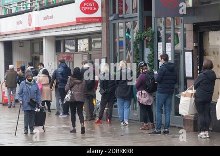 Das Postamt in der Clapham High Street mit einer Warteschlange vor ihm am 21. Dezember 2020. Diese Niederlassung soll trotz starker lokaler Opposition und des Mangels an weiteren Poststellen in der Nähe geschlossen werden. Anna Watson/Alamy Stockfoto