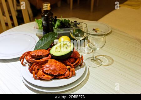 In Nahaufnahme gekochte rote Krabben, Avocado, Lorbeer, Weingläser, Olivenöl, Salat Stockfoto