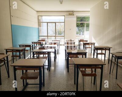 Ein leeres helles Klassenzimmer mit Schreibtischen ohne Schüler wegen Covid-19 Stockfoto