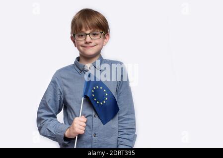 Serious jugendlich Junge hält EU-Flagge isoliert auf weißem Hintergrund. Student mit einer Flagge Europas in den Händen Stockfoto