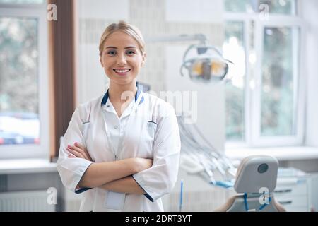 Fröhliche schöne Zahnarzt wartet auf Patienten in der Klinik Stockfoto
