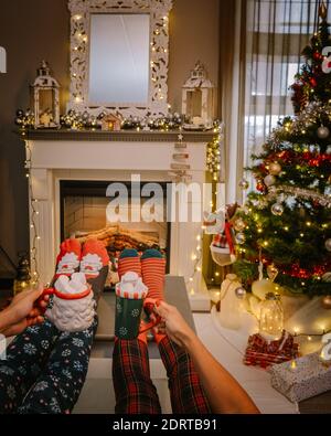 Weihnachtsbaum und Kamin, Weihnachtsstrümpfe und heiße Schokoladenbecher am Kamin während der Weihnachtsferien Stockfoto