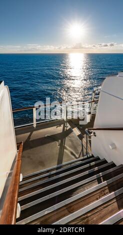 Blick auf den Sonnenuntergang von der Treppe draußen auf einem Segelschiff. Stockfoto