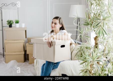 Pappkarton mit persönlichen Gegenständen in den Händen einer jungen Frau Stockfoto