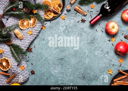 Winter Weihnachtskomposition mit Glühwein in einem braunen Keramikbecher. Arbeitsbereich mit braunem Umschlag und Zutaten für Glühwein. Weibliche Hand Stockfoto