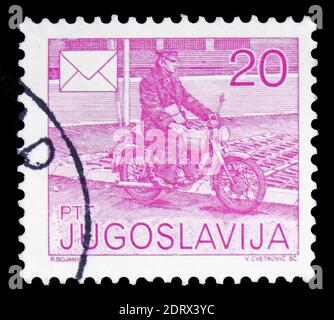 MOSKAU, RUSSLAND - 10. FEBRUAR 2019: Eine in Jugoslawien gedruckte Briefmarke zeigt Mailman auf Motorrad, Postal Services Serie, um 1986 Stockfoto