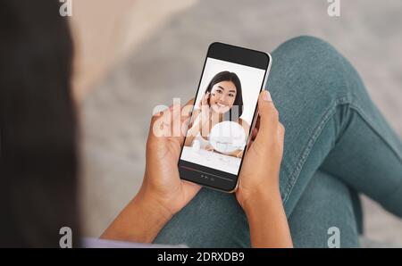 Unkenntlich schwarze Dame mit Smartphone zu Beauty-Blogger online zu sehen, unter Bildungskurs auf Make-up Stockfoto