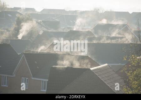 Dampf aus Heizungsanlagen und Dächern, die nach einer kalten Nacht von der Morgensonne erwärmt werden. England GB Stockfoto