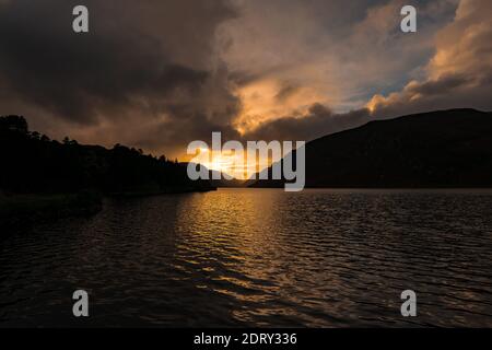 Spektakuläre Aussicht im Glenveagh National Park, orangefarbener Sonnenuntergang, flauschige Wolken, Lough Veagh und Derryveagh Mountains nordwestlich von County Donegal, Irland Stockfoto