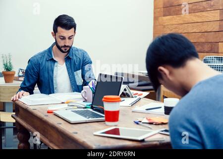 Zwei junge Unternehmer, die Vorbereitung ihrer neuen Business-Projekts in eine moderne Coworking-espace Stockfoto