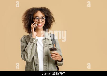 Moderner Arbeiter, Freiberufler oder Blogger. Lächelnd teen afrikanisch amerikanisch lockig Dame in Brille Stockfoto