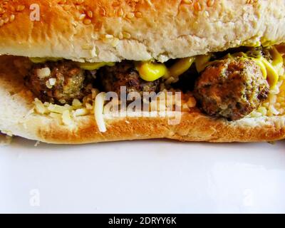 Griechisches Fleischbällchen-Sandwich mit geriebenem Käse und Senf Stockfoto