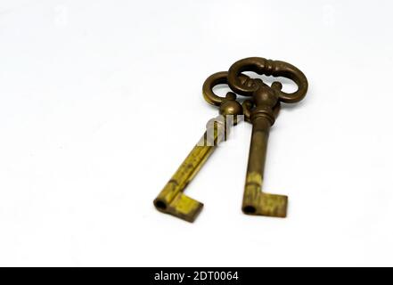 Ein Paar alte oxidierte Messingschlüssel isoliert auf weißem Hintergrund. Sicherheits- und Schutzkonzept Stockfoto