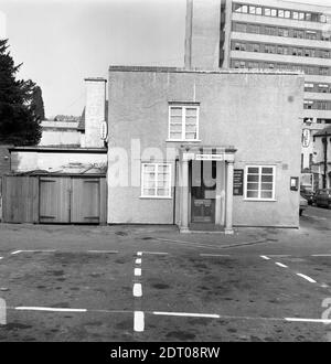The Duke of York pub in Kingston, Yeovil. Photo taken in 1973. The main pub (see photos b and c) on the main road, was rebuilt in 1905 but this later rear elevation is more box-like. The sign over the door is for The Albany Lounge whereas the menu board advertises the Albany Bar and the perspex hanging sign has been smashed. The gallows sign on the front corner is for "Lounge, Buffet Bar Car Park at Rear." There is no brewery signage visible however photos c and d (maybe taken later as on 35mm negatives) show a Bass gallows sign. The corner shop sign is for what looks like Sophia Perrett.0085a Stockfoto
