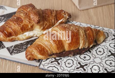Eine Nahaufnahme von Mini-Croissants gefüllt mit Schokolade und Butter auf dem Tisch. Französische Küche Stockfoto