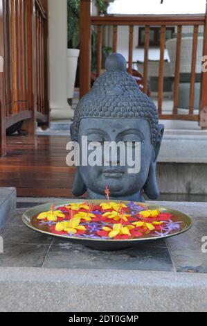 Buddha-Statue mit Blumen auf der Insel praslin auf den seychellen Für eine mystische und spirituelle Erfahrung Stockfoto