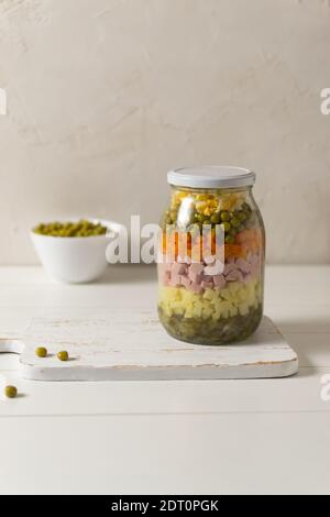 Zutaten für Olivier Salat russisch in einem Glas auf weißem Hintergrund. Russische Küche. Speicherplatz kopieren. Stockfoto