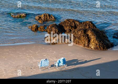 Stühle am felsigen Strand in Wells Village, Maine Stockfoto