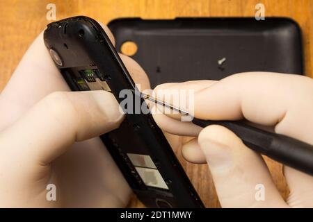 Demontage eines alten Telefons für die Reparatur auf einem Tisch Stockfoto