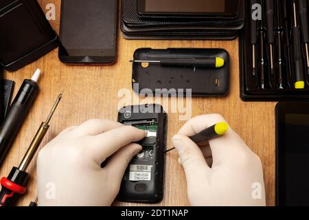 Demontage eines alten Telefons für die Reparatur auf einem Tisch Stockfoto