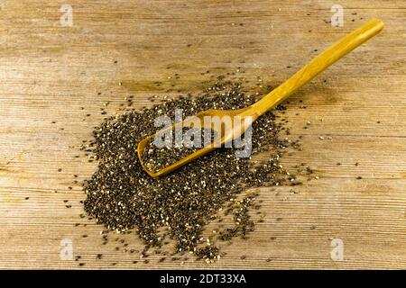 Chia Samen Salvia hispanica in Holzlöffel auf alten Holztisch Hintergrund. Gesunde Lebensmittel, Superfood Stockfoto