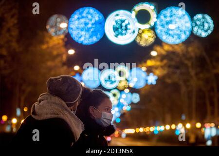 Barcelona, Spanien. Dezember 2020. Eine Frau, die eine schützende Gesichtsmaske trägt, geht an den Weihnachtsdekorationsleuchten in Barcelona vorbei. Quelle: Jordi Boixareu/Alamy Live News Stockfoto