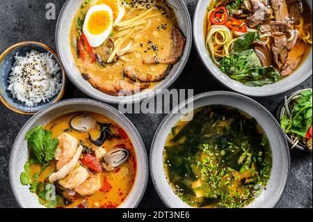 Asiatische Suppen, Miso, Ramen, Tom Yam, Pho Bo. Schwarzer Hintergrund. Draufsicht. Stockfoto