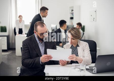 Praktikum eines neuen Mitarbeiters am Arbeitsplatz. Schulung in offiziellen Aufgaben. Abteilungsleiter und Untergebener im Büro Stockfoto