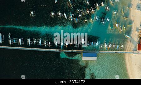 Lange Seebrücke mit angelegten Boote am Morgen, Luftbild. Allgemeine Luna, Siargao Island. Stockfoto