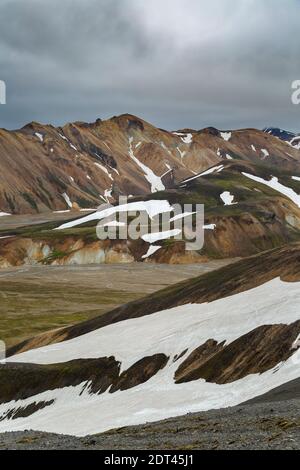 Rhyolit Berge teilweise in Schnee, Landmannalaugar, Fjallabak Nature Reserve, Island Stockfoto