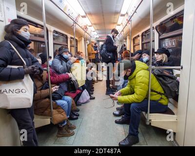 Passagiere mit Masken als vorbeugende Maßnahme gegen die Verbreitung von covid-19 auf der Moskauer U-Bahn.die Stadt Moskau bereitet sich auf die Weihnachts- und Neujahrsfeiertage zu feiern. Im Jahr 2020 wurde die vorfeierliche Atmosphäre durch die Covid19-Pandemie verdunkelt. In Geschäften, öffentlichen Verkehrsmitteln und anderen öffentlichen Innenräumen müssen Gesichtsmasken und Handschuhe getragen werden. Stockfoto