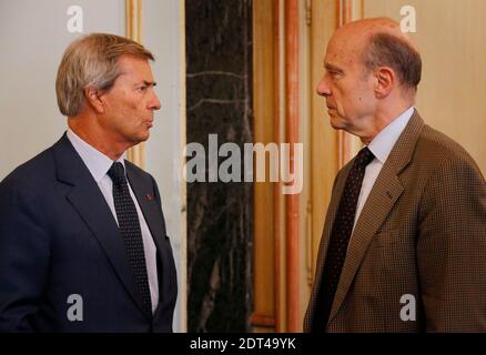 Der Bürgermeister von Bordeaux Alain Juppe spricht mit dem CEO der Bollore-Gruppe Vincent Bollore, während sie am 9. Januar 2014 in Bordeaux, Südwest-Frankreich, auf die Lieferung von Bluecub-Autos warten. Foto von Patrick Bernard/ABACAPRESS.COM - Bordeaux Stockfoto