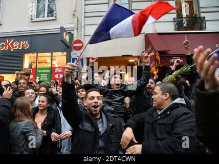 Fans des französischen Comics Dieudonne M'Bala M'Bala treffen sich in der Nähe eines Pariser Theaters, als einer von ihnen am 11. Januar 2014 in Paris die französische Nationalflagge schwingt und eine Ananas hält. Dieudonne wurde wiederholt wegen Anstiftung zu Rassenhass oder Antisemitismus verurteilt und hat zugestimmt, eine umstrittene Show aufzugeben, die in mehreren Städten verboten wurde. Nachdem eine Pariser Show heute von den Behörden verboten wurde, sagte er einer Pressekonferenz, dass er die "Le Mur" Show nicht mehr machen werde, sondern sie durch eine neue Performance ersetzen werde. Der Comic wurde im vergangenen Herbst für die Verwendung des Wortes "Shoanana verurteilt Stockfoto