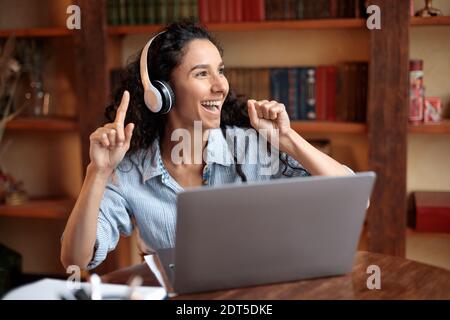 Frau, die online Musik im Headset hört und tanzt Stockfoto
