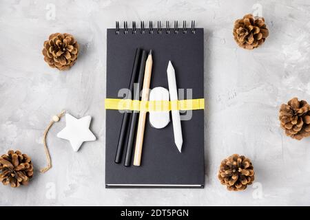 Skizzenbuch oder Notizbuch, Bleistift, Radierer, Tannenzapfen Stockfoto