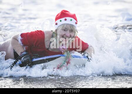 Swansea, Wales, Samstag, 19. Dezember 2020. Fundraiser, Susie Davies-Lowe Bodyboarding während des Surfing Santas Events im Meer bei Langland Bay auf Gower, Swansea, um Geld für Surfer gegen Kanalisation zu sammeln. Kredit: Robert Melen. Stockfoto