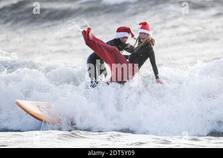 Swansea, Wales, Samstag, 19. Dezember 2020. Zwei lokale Surfer in den Wellen während der Surf Santas Veranstaltung im Meer in Langland Bay auf Gower, Swansea, um Geld für Surfer gegen Kanalisation zu sammeln. Kredit: Robert Melen. Stockfoto