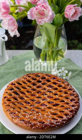 Kirschkuchen mit Teiggitter aus Limburg, Niederlande serviert in sonnigen Garten Stockfoto