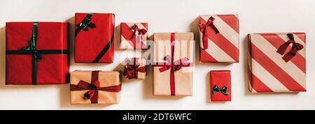 Flache Geschenkschachteln aus festlichem Handwerk in Geschenkpapier, verziert mit Bändern und Schleifen auf weißem Hintergrund, Draufsicht. Weihnachten Boxtag Konzept Stockfoto