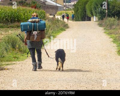 Camino Pilger mit seinem Hund in der Nähe von Astorga - San Justo de la Vega, Kastilien und Leon, Spanien Stockfoto