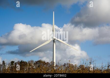 Windturbine, die Energie mit Luftströmung mit sich drehenden Rotorblättern erzeugt Stockfoto