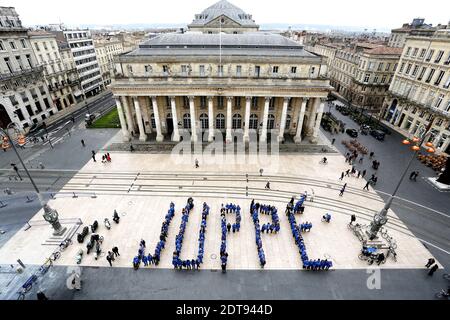 Unterstützer des UMP-Bürgermeisters von Bordeaux und Kandidat für die bevorstehenden Bürgermeisterwahlen Alain Juppe, bilden seinen Namen auf dem Place de la Comedie während einer Versammlung zur Unterstützung seines Wahlkampfes am 16. März 2014 in Bordeaux. Foto von Patrick Bernard-Quentin Salinier/ABACAPRES.COM - Bordeaux Stockfoto