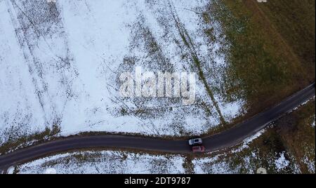 Drohnenfoto von zwei Autos, die im Winter aneinander vorbeifahren Auf schmaler Straße Stockfoto