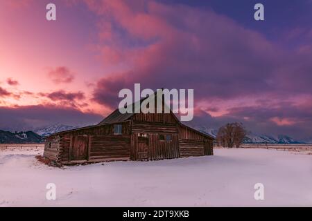 Malerische Winterlandschaft mit Molton Barn bei Sonnenuntergang auf der Mormon Row im Grand Teton National Park, Jackson Hole, Wyoming, USA Stockfoto