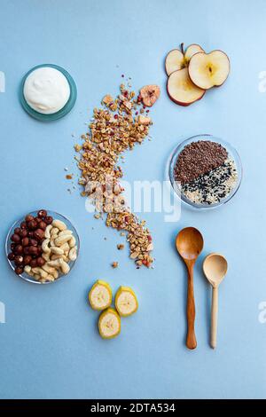Gesundes Frühstück. Granola mit Himbeeren, schwarzen und weißen Sesamsamen, Leinsamen, Cashewkernen, Haselnüssen, Apfelkeilen und Banane. Gesunde Ernährung conce Stockfoto