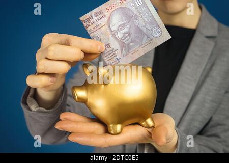 Nahaufnahme Frau Hände mit indischen Rupie und Geldbox. Stockfoto