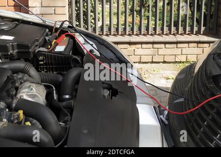 Laden der Batterie von einem anderen Fahrzeug mit Überbrückungskabeln Stockfoto