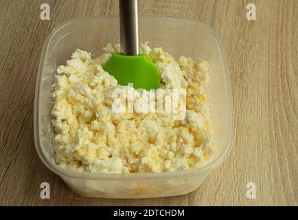 Frischer Hüttenkäse mit Ei. Für Brötchen, Entsafter, Käsekuchen und Lebkuchen mischen Stockfoto